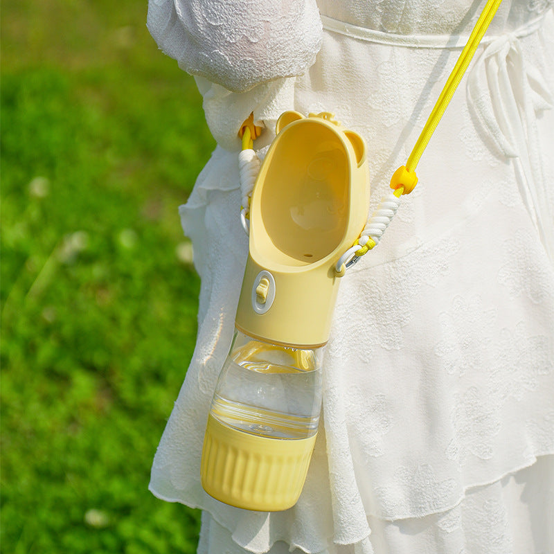 Yellow TrailSip bottle carried by its strap during an outdoor walk